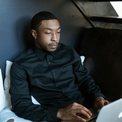 Man in Black Jacket Sitting on Black Couch