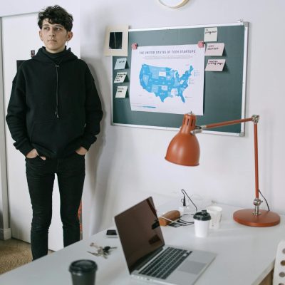 Man in Black Jacket Standing Near White Wall