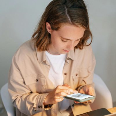 Woman in White Button Up Shirt Using White Smartphone